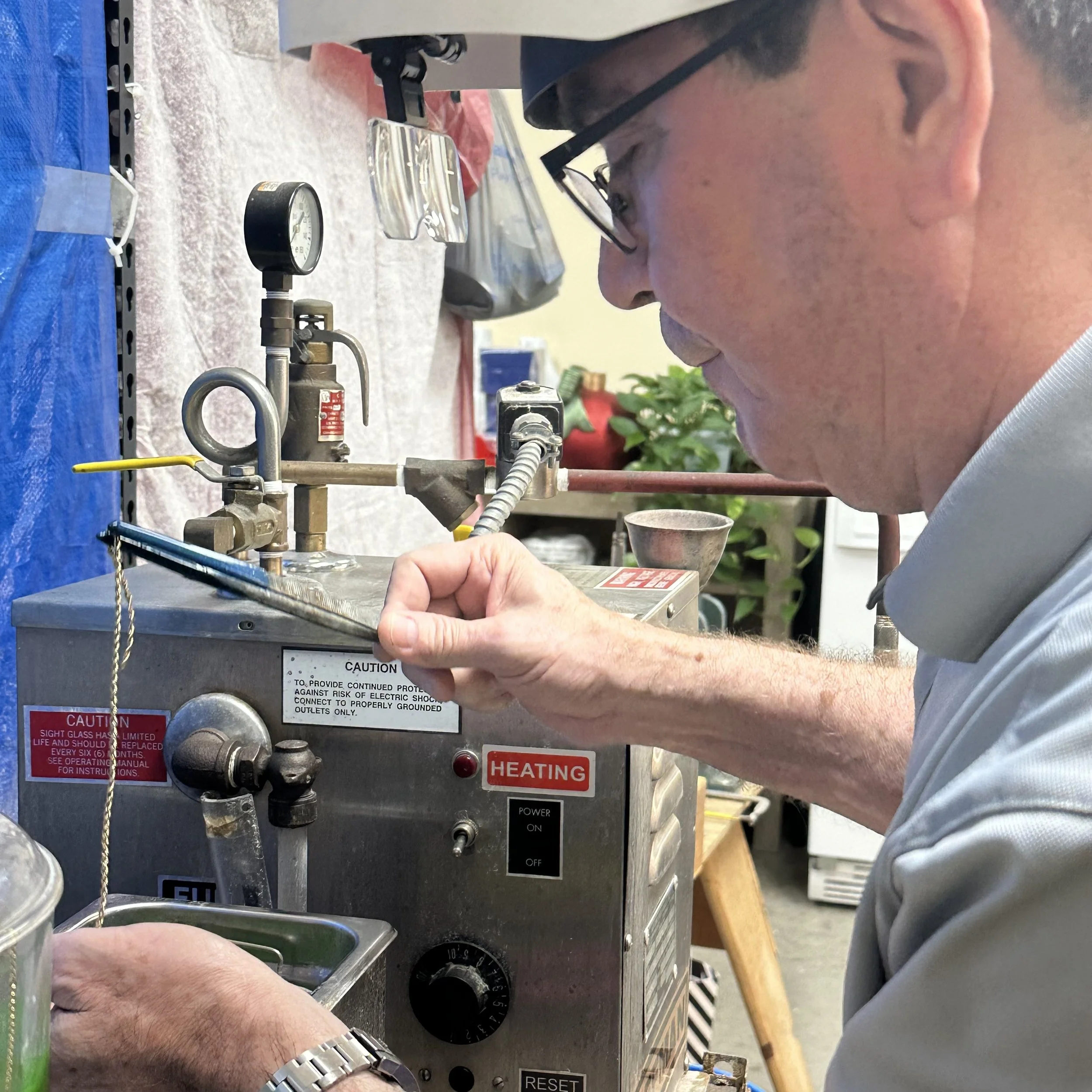 Nelson lifts a chain from the jewelry cleaner