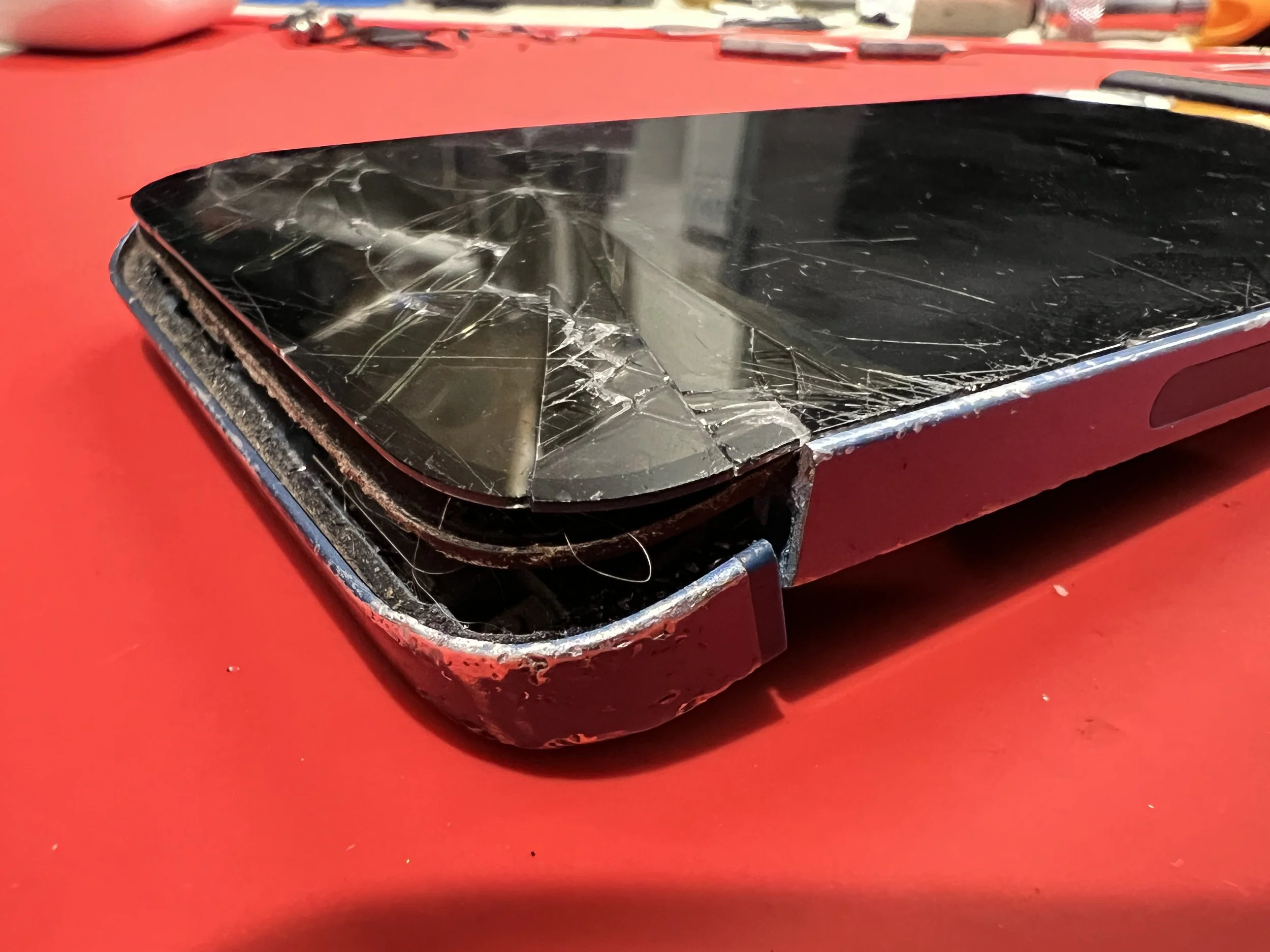 Blue iPhone 13 with broken screen and frame