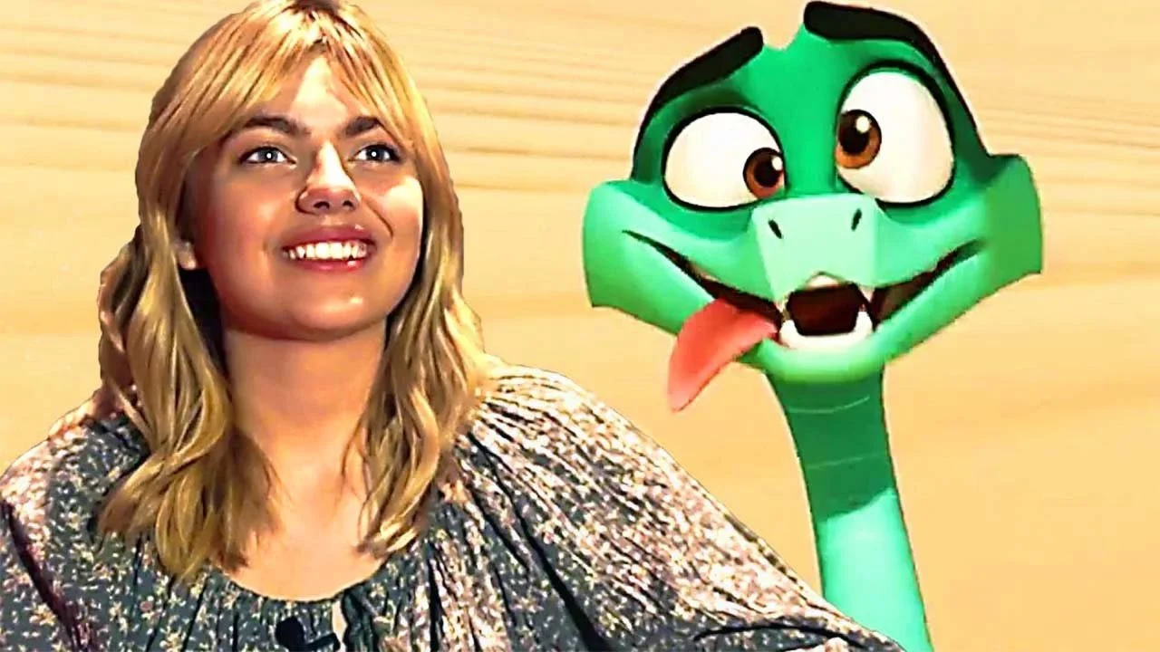 Une femme souriante assise à côté d'un personnage de dessin animé une girafe verte avec une langue sortie.