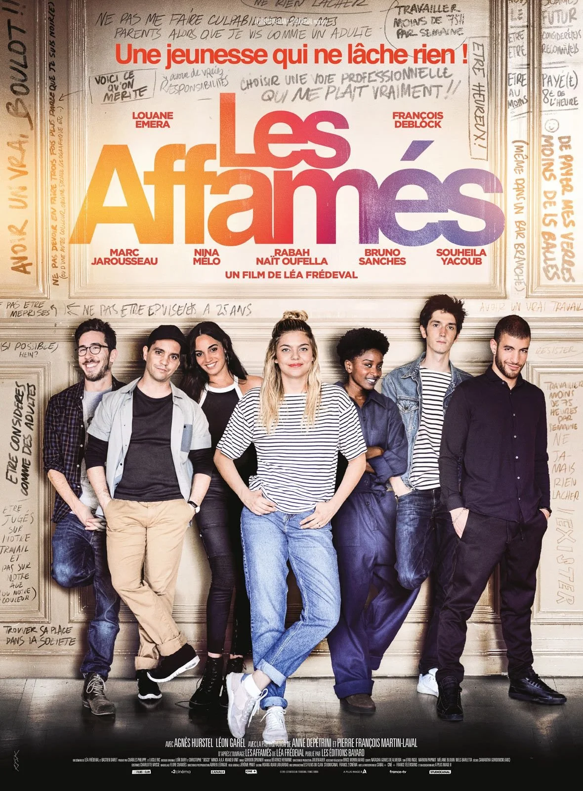 Affiche du film 'Les Affamés' avec un groupe de jeunes adultes devant un mur avec des notes manuscrites.