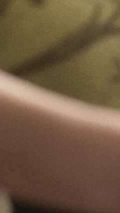 Close-up of a beige surface with a greenish background.