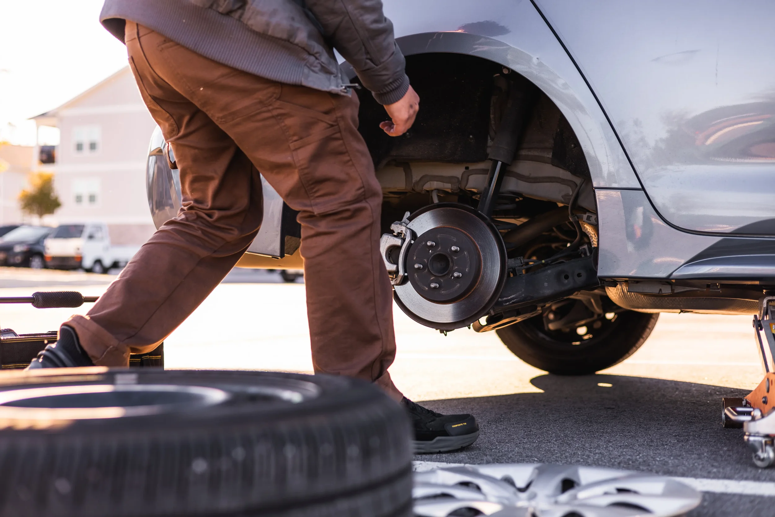 Mobile brake repair technician servicing brake rotor and pads during on-site brake job
