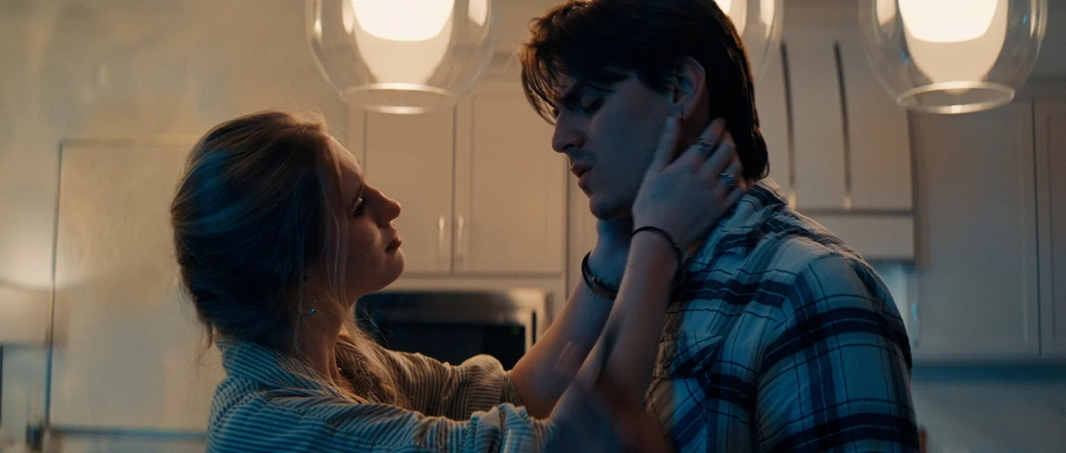 Still from 8 Count: a couple in a kitchen, her hand on his face