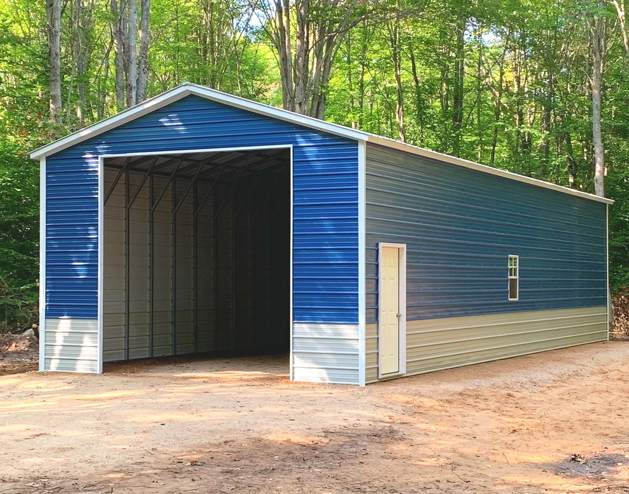 Blue and beige metal storage building in a wooded area, with a small door and a window on the side.