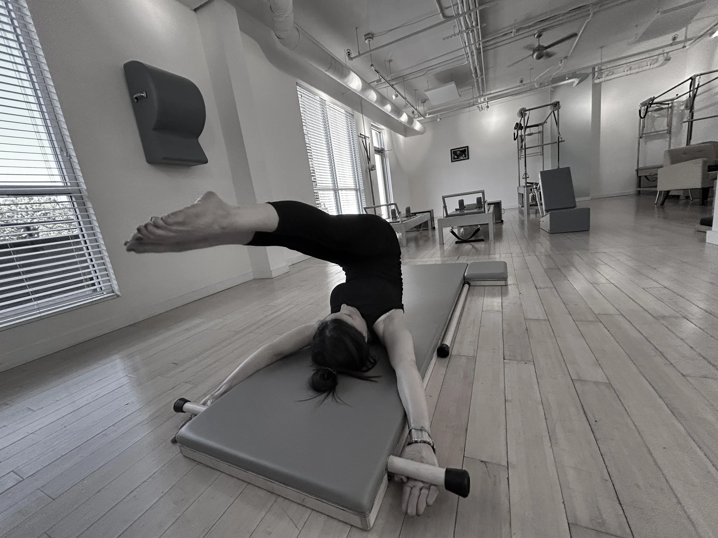 Client performing corkscrew exercise on Pilates mat in Davis CA