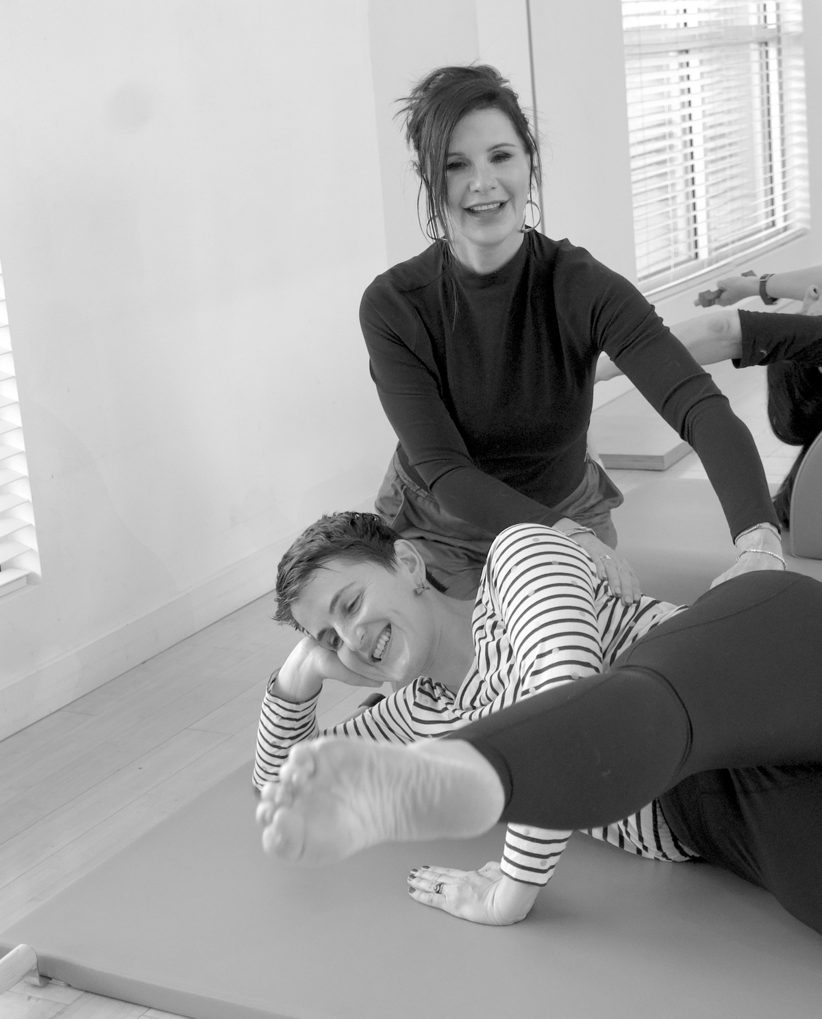 Instructor assisting client with side kicks exercise during private Pilates session in Davis CA