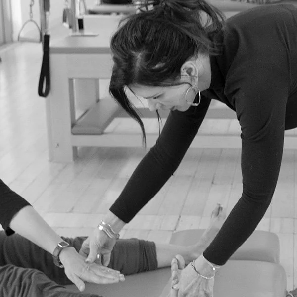 Instructor assisting client during classical Pilates session in Davis CA