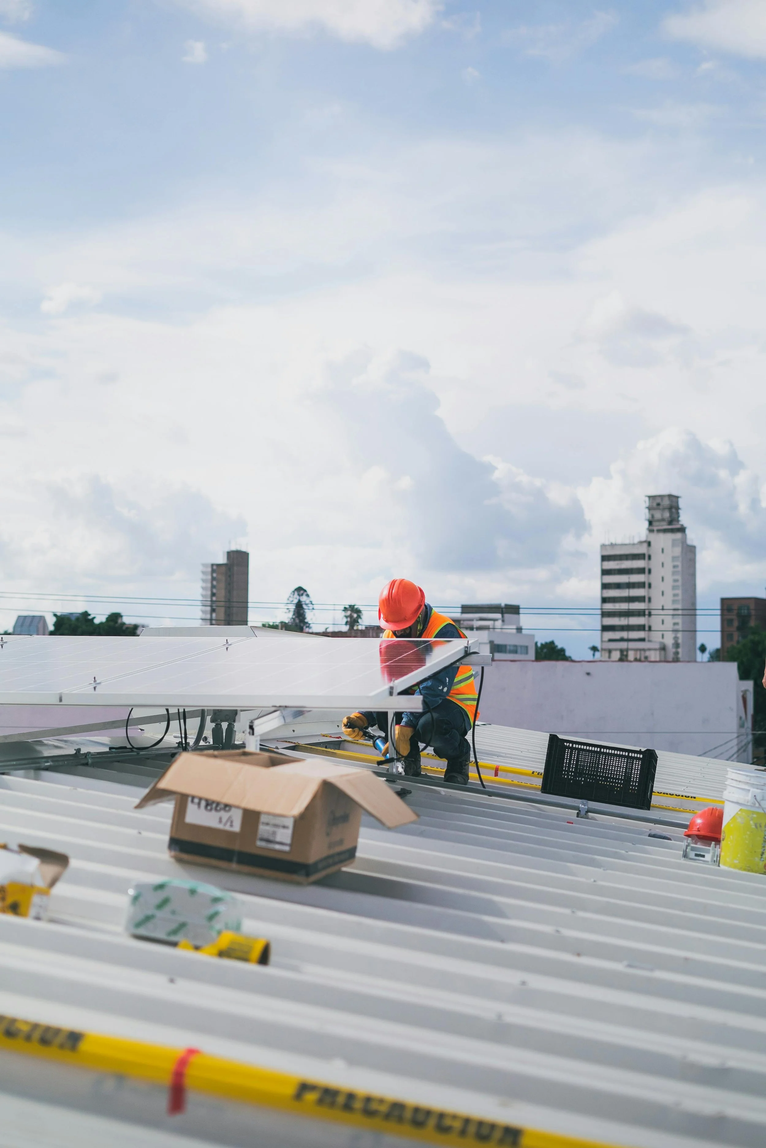 Ingeniero certificado, instalando paneles solares en un tejado en una ciudad.