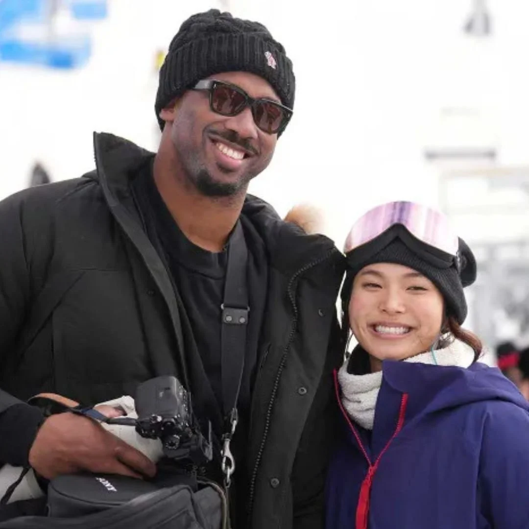 A man and woman dressed in winter clothing, smiling and posing together in a snowy outdoor setting.