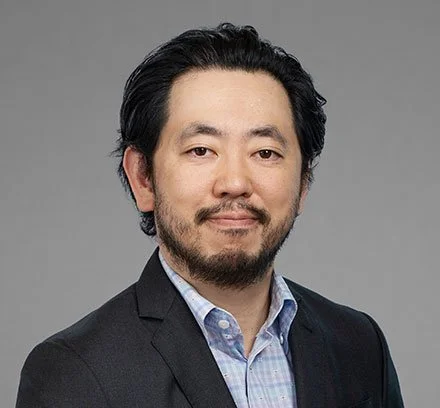 NYC Footy's Michael Chung. Man with short dark hair and beard in business attire.