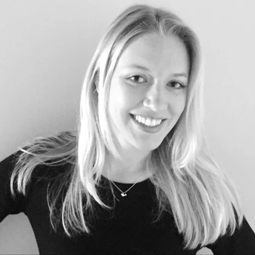 NYC Footy's Sarah Clasing. Black and white photo of a smiling woman with long hair wearing a dark shirt and a necklace.