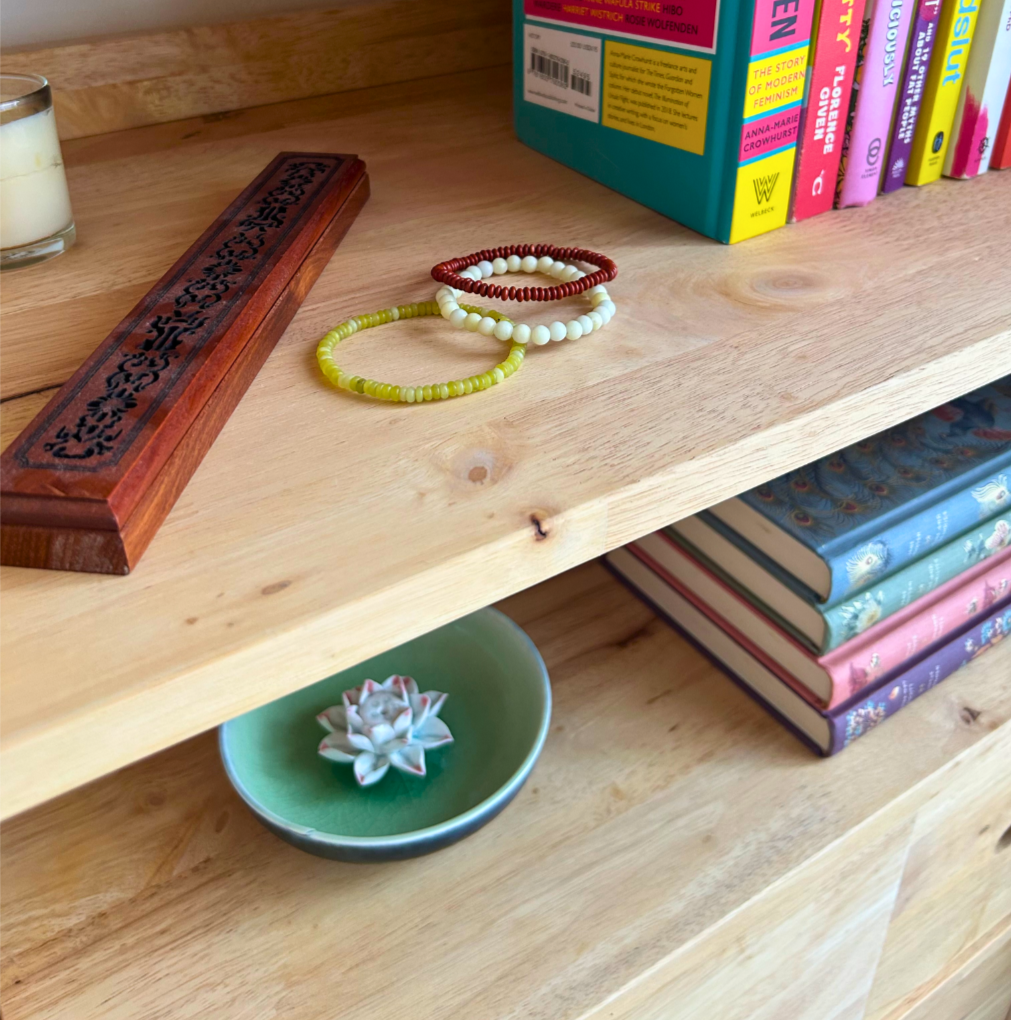 Feminist books on bookshelf with additional decoration to feel grounded and calm