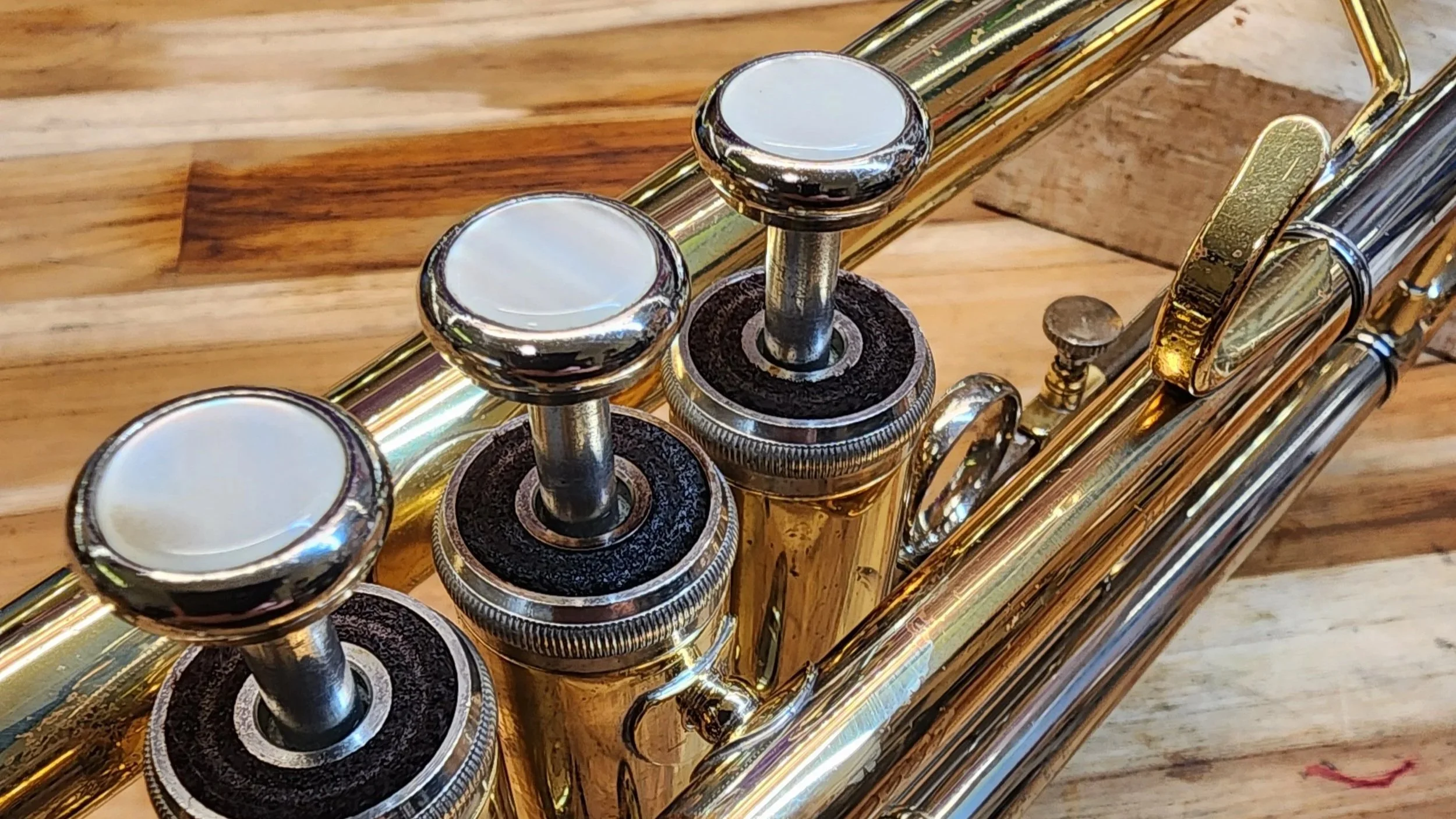 A close-up view of a trumpet resting on a wooden surface.