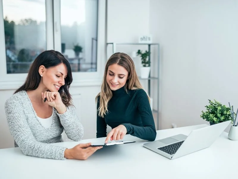 Two professionals reviewing employee benefits plan options together at a desk, representing the hands-on, personal service Core Group Consulting provides.