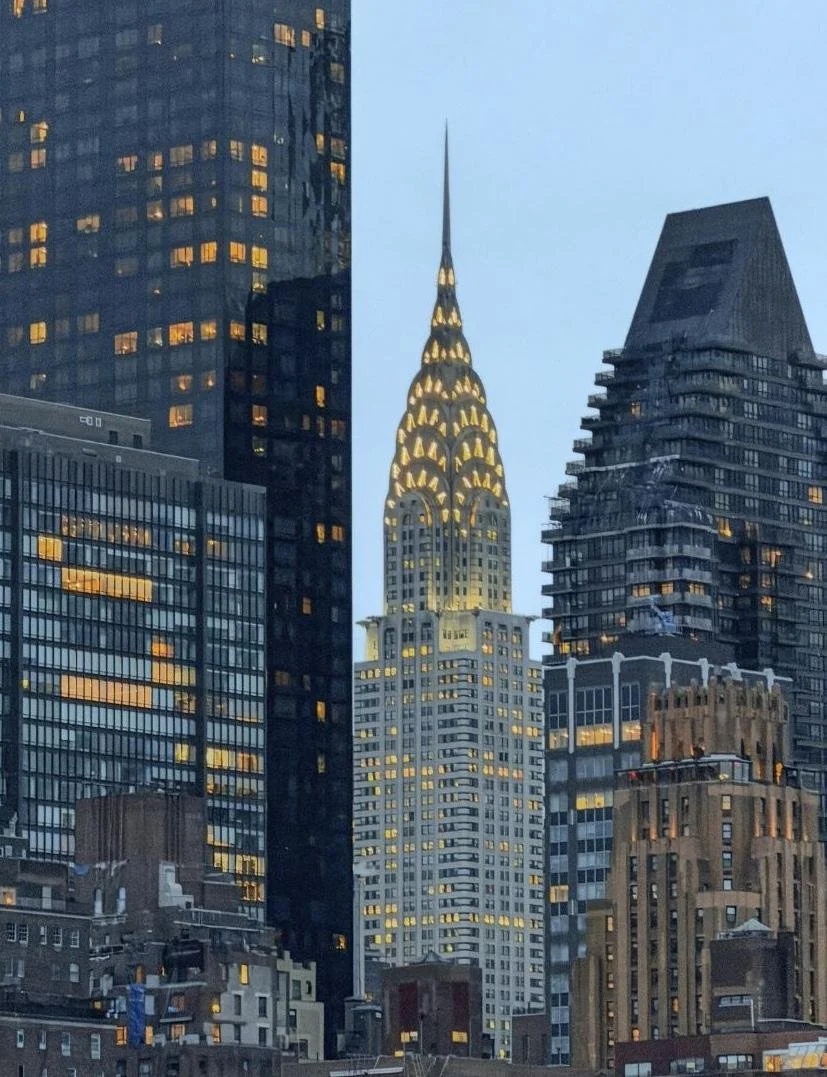 The illuminated Chrysler Building rises among Manhattan skyscrapers at dusk — a landmark view of the New York City skyline where Core Group Consulting is based.
