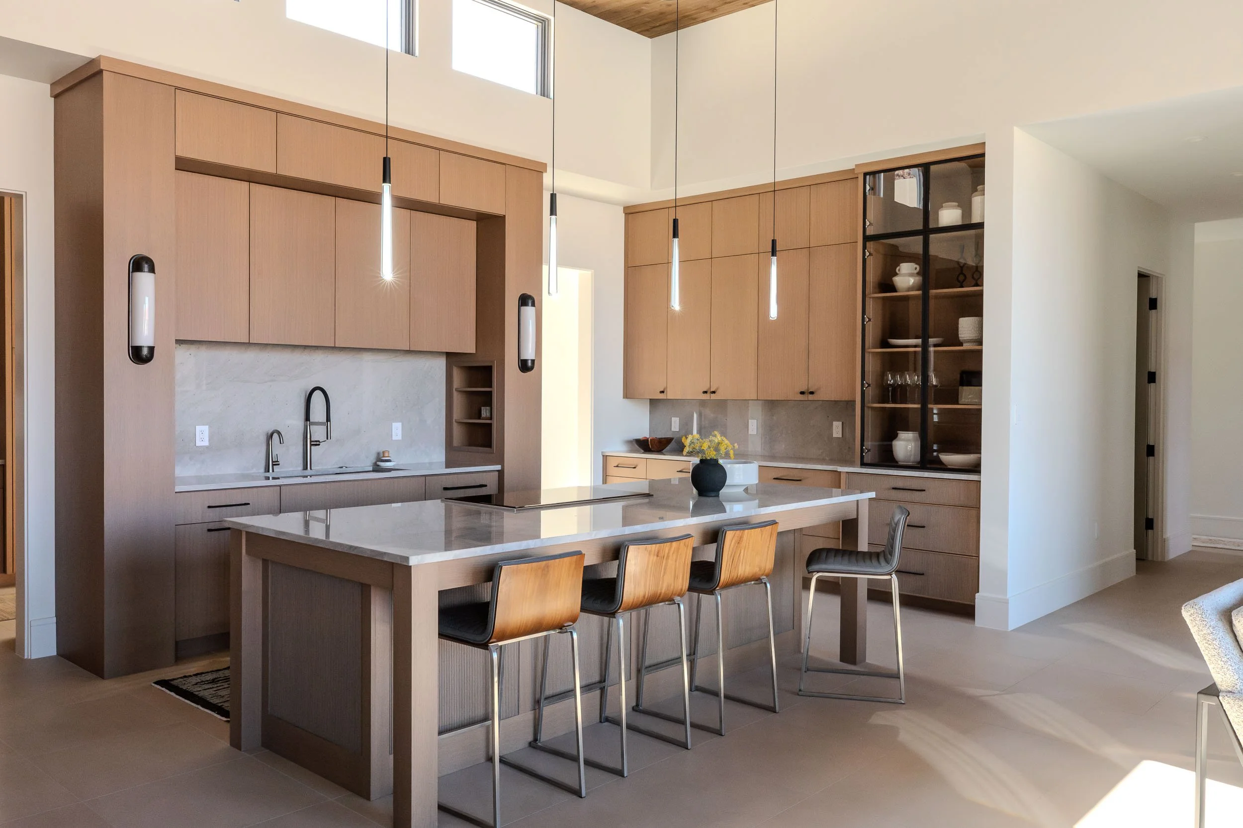 Large kitchen with white oak cabinets and sleek pendants and quartzite countertop