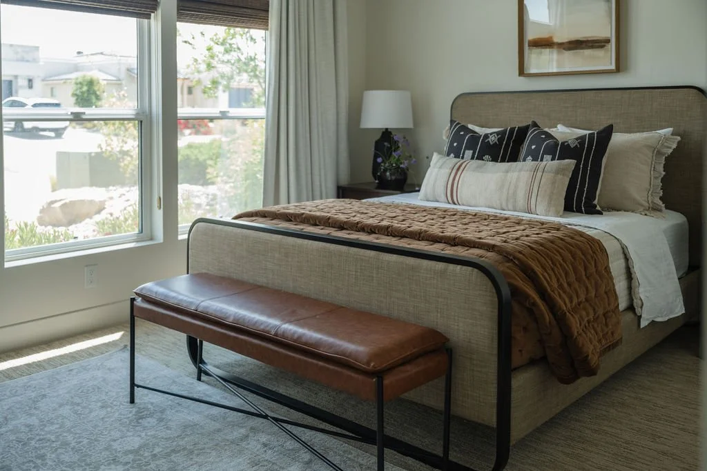 Cozy guest bedroom with neutral bedding, layered textiles, and a welcoming ambiance for visitors.
