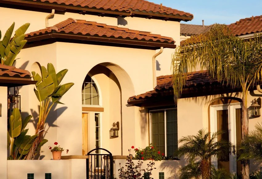 Spanish Colonial style house exterior with arched entryways, and terracotta roof tiles for a warm, inviting look.