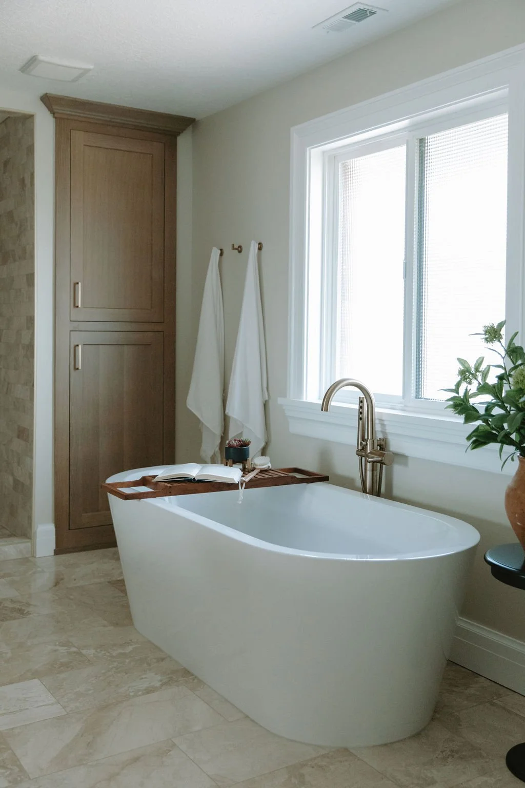 Luxury bathroom with a freestanding soaking tub, gold fixtures, and built-in cabinetry for a spa-like experience.