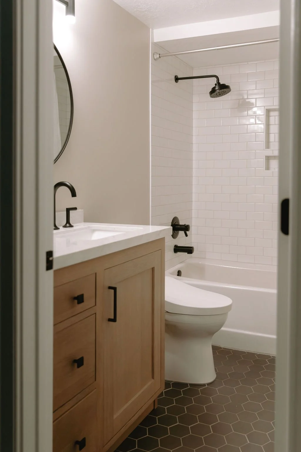 Modern guest bathroom with warm wood cabinetry, a white quartz countertop, and black fixtures for a sleek contrast.