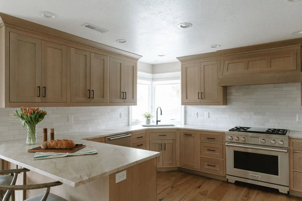 Transitional kitchen with light wood cabinets, white subway tile backsplash, and a quartz countertop island with seating.
