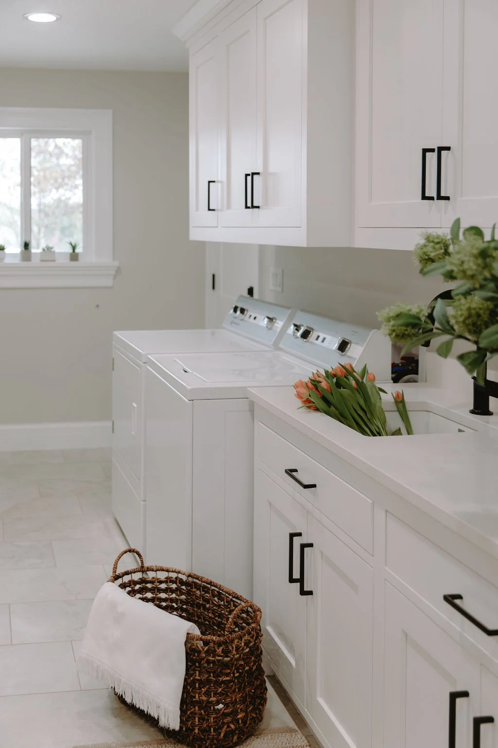 Functional laundry room with a side-by-side washer and dryer, ample storage, and a bright, airy feel.