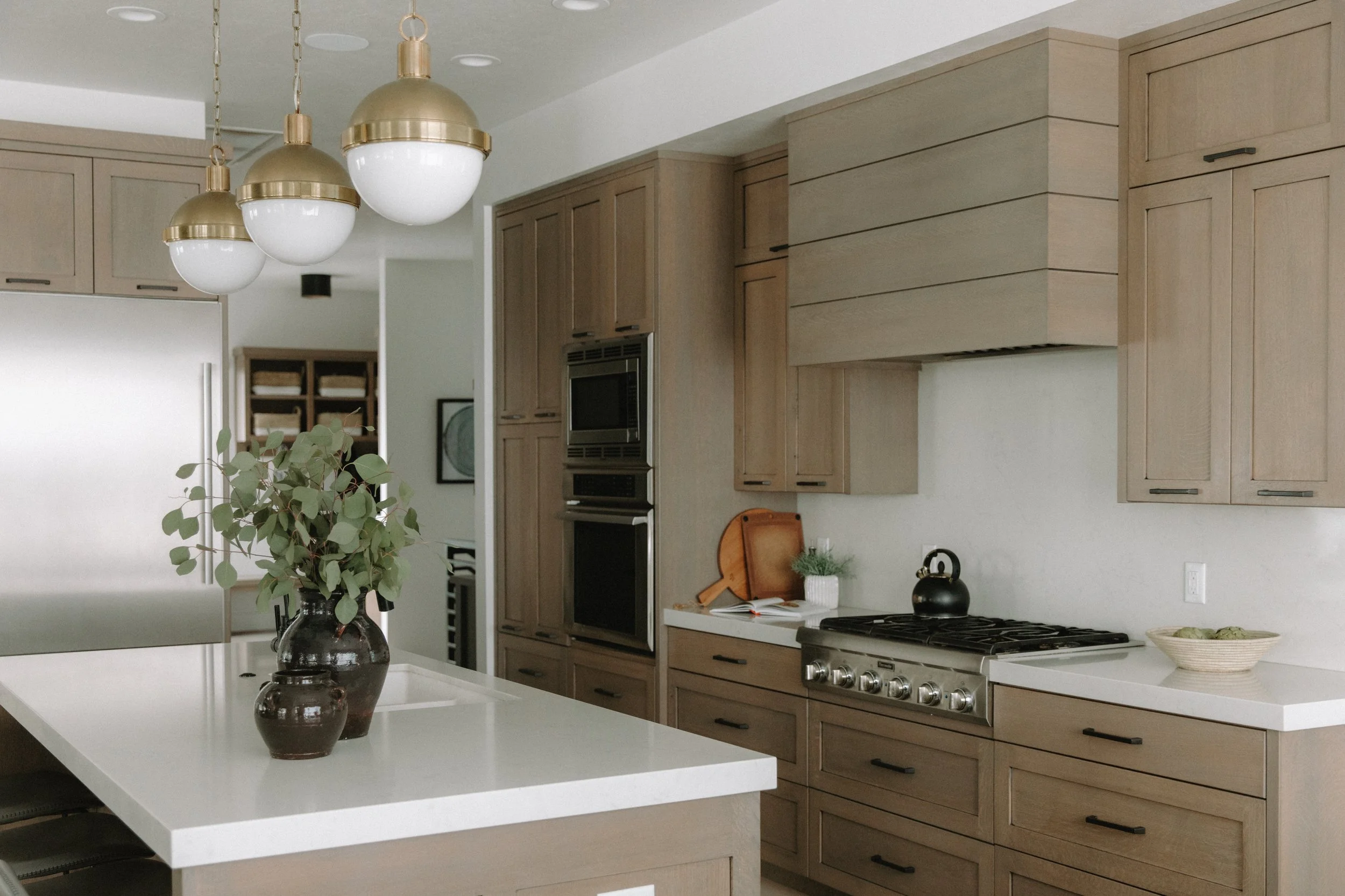 Modern organic kitchen with pendant lighting and flower vase on counter top