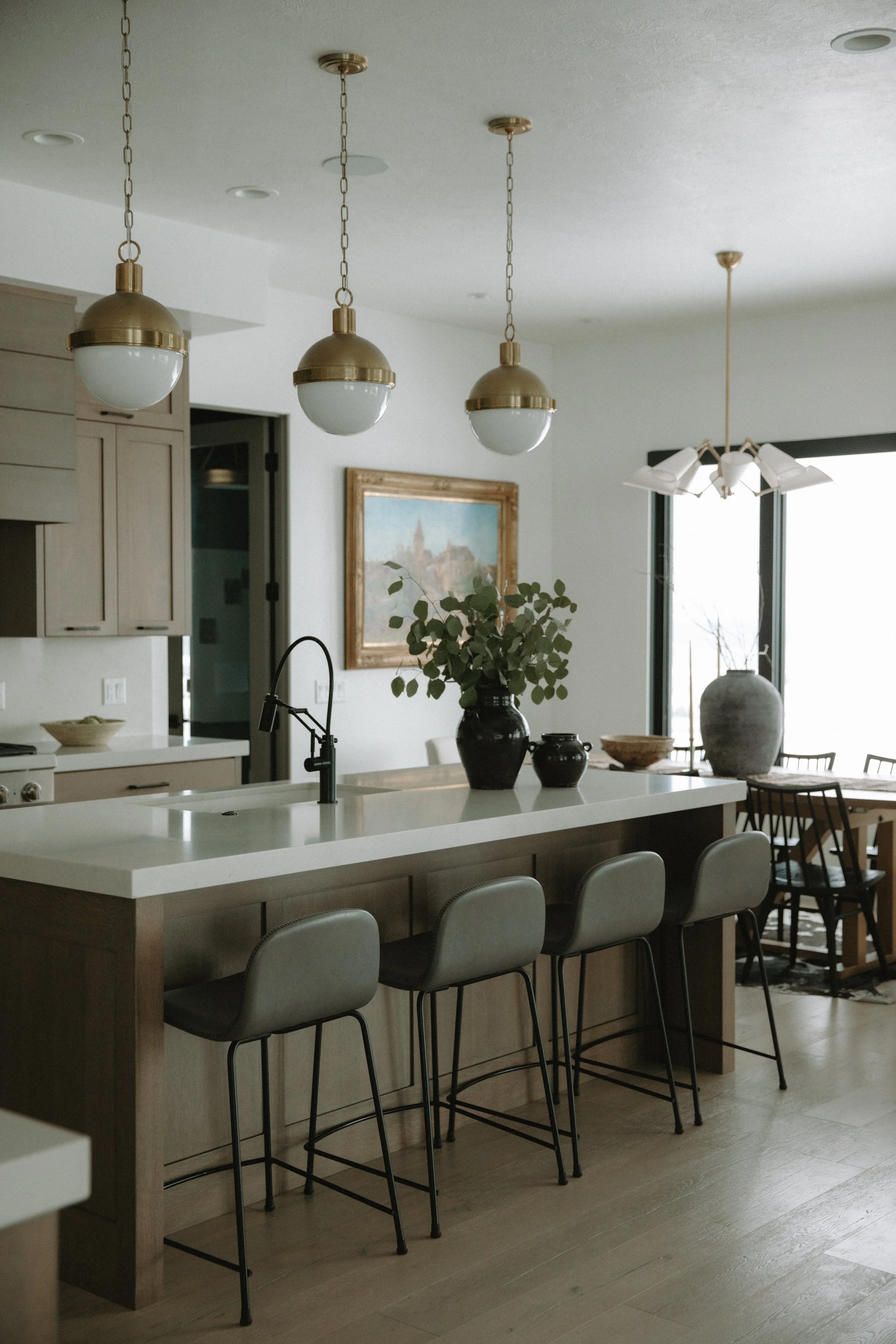 Modern and natural kitchen with gold pendant lighting and bar high counter top with seating
