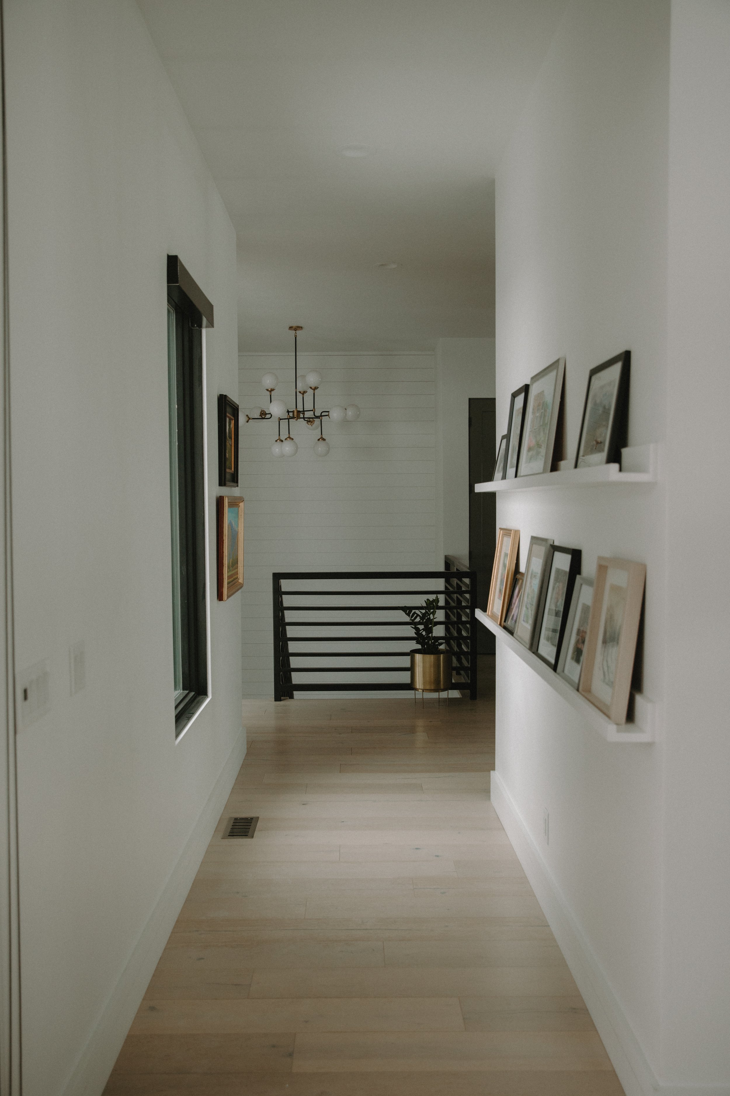 Hallway floating shelving filled with pictured frames