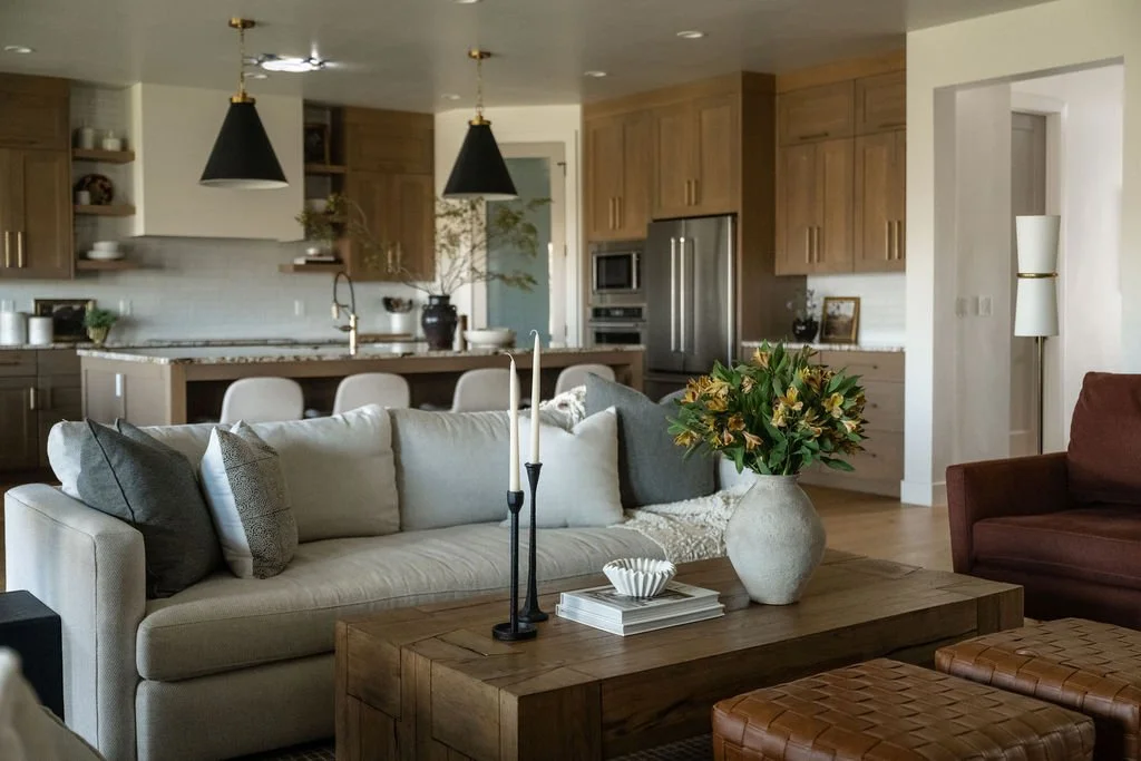 Contemporary living room with layered textiles, a rustic wood coffee table, and a neutral color palette in a vacation home setting.