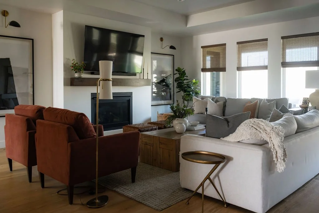 Cozy living room with layered textures, a modern fireplace, neutral furnishings, and desert views.