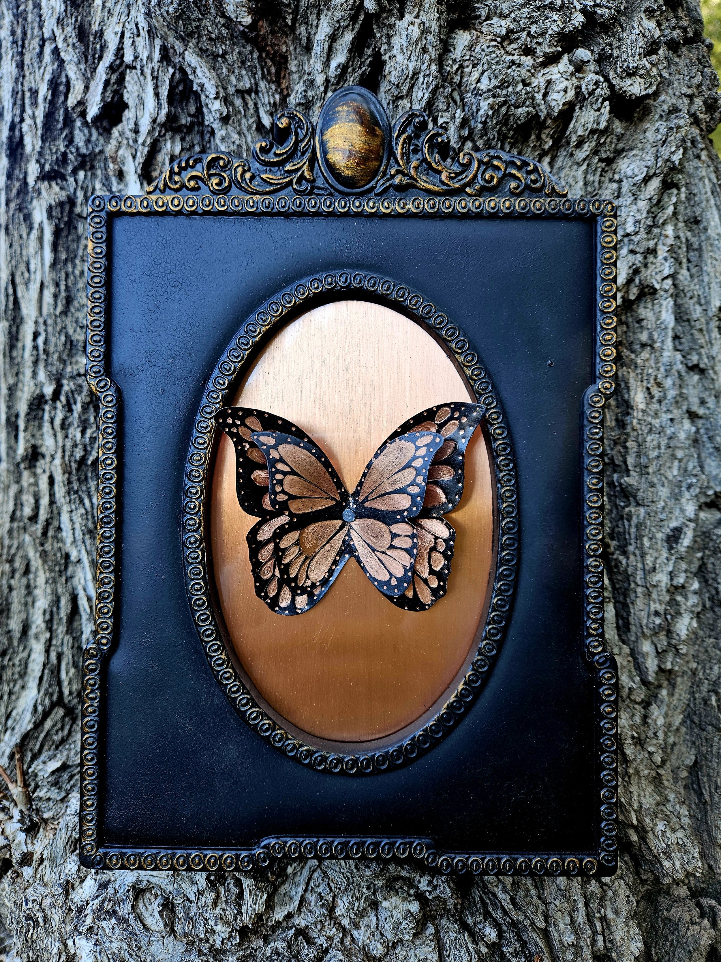 Decorative framed butterfly art mounted on the bark of a tree.