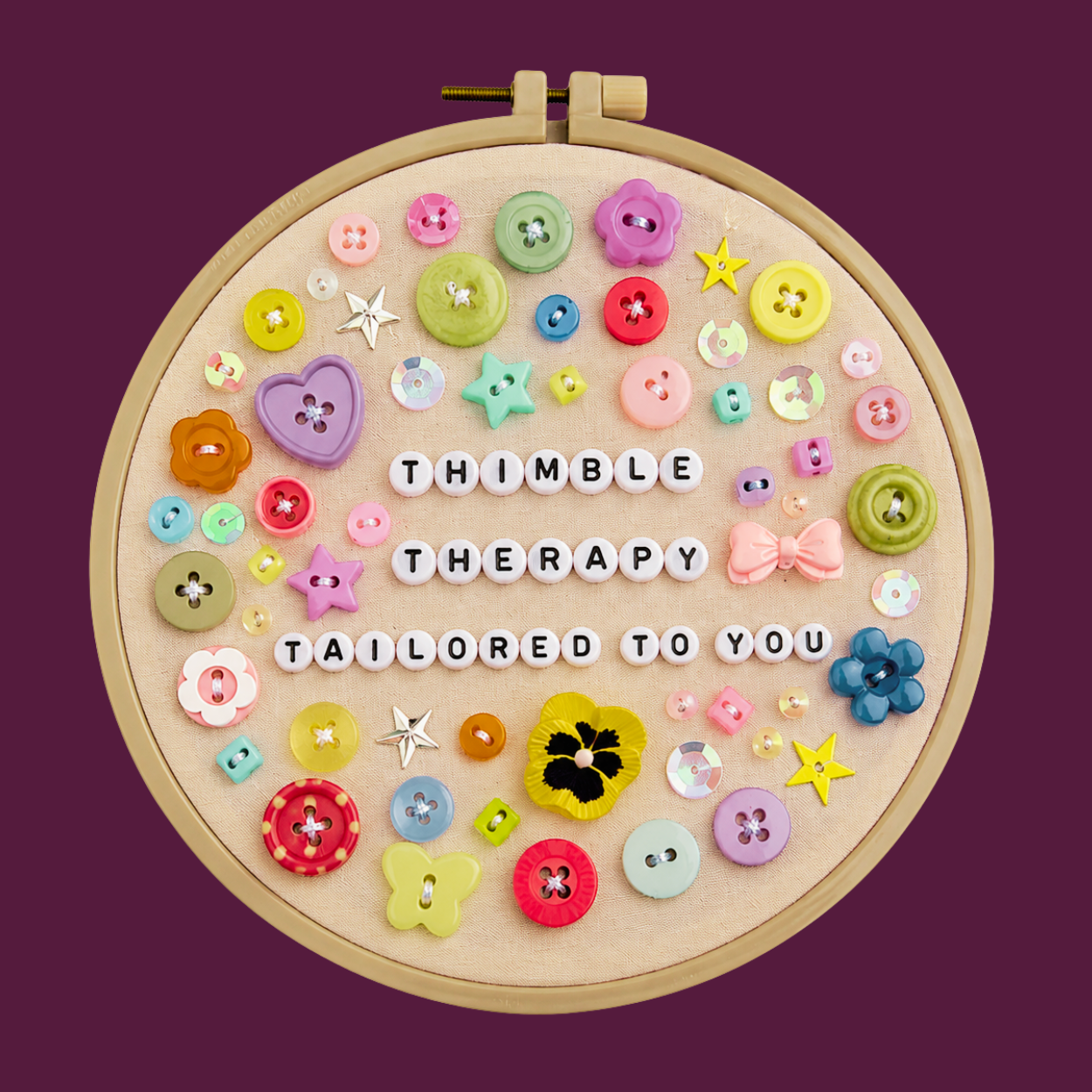 Colorful beads and buttons arranged around a message that reads 'Thumble Therapy Tailored to You' on a fabric-covered embroidery hoop.