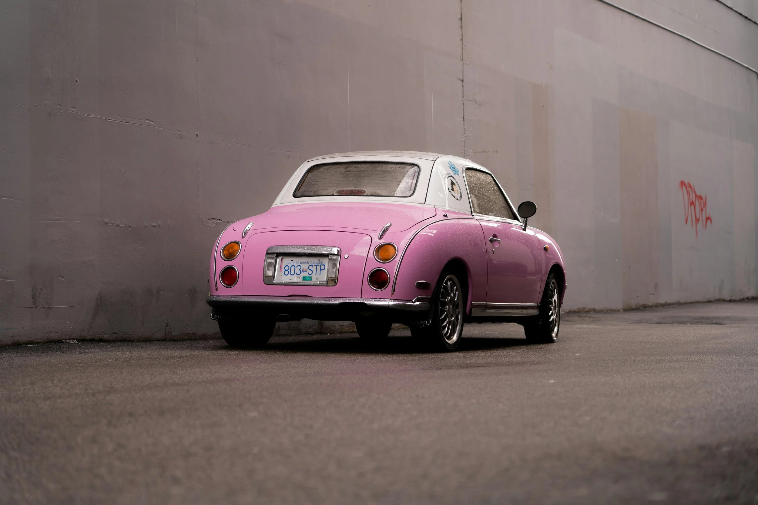 A pink car on a neutral background.