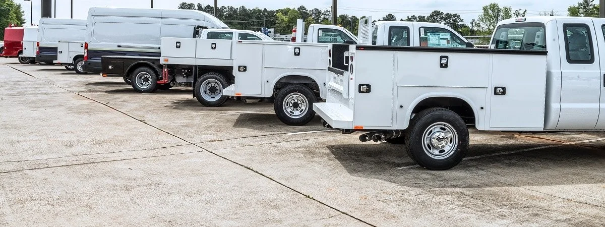 Commercial fleet vehicles prepared for de-identification and logo removal services in Texas.