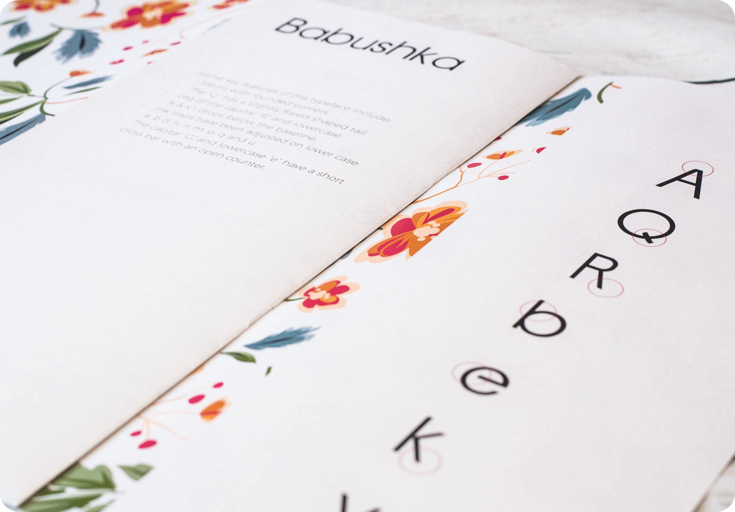 Close-up of a book about baby's anatomy, with colorful floral designs on the pages, and the word 'BABOUSHKA' at the top.