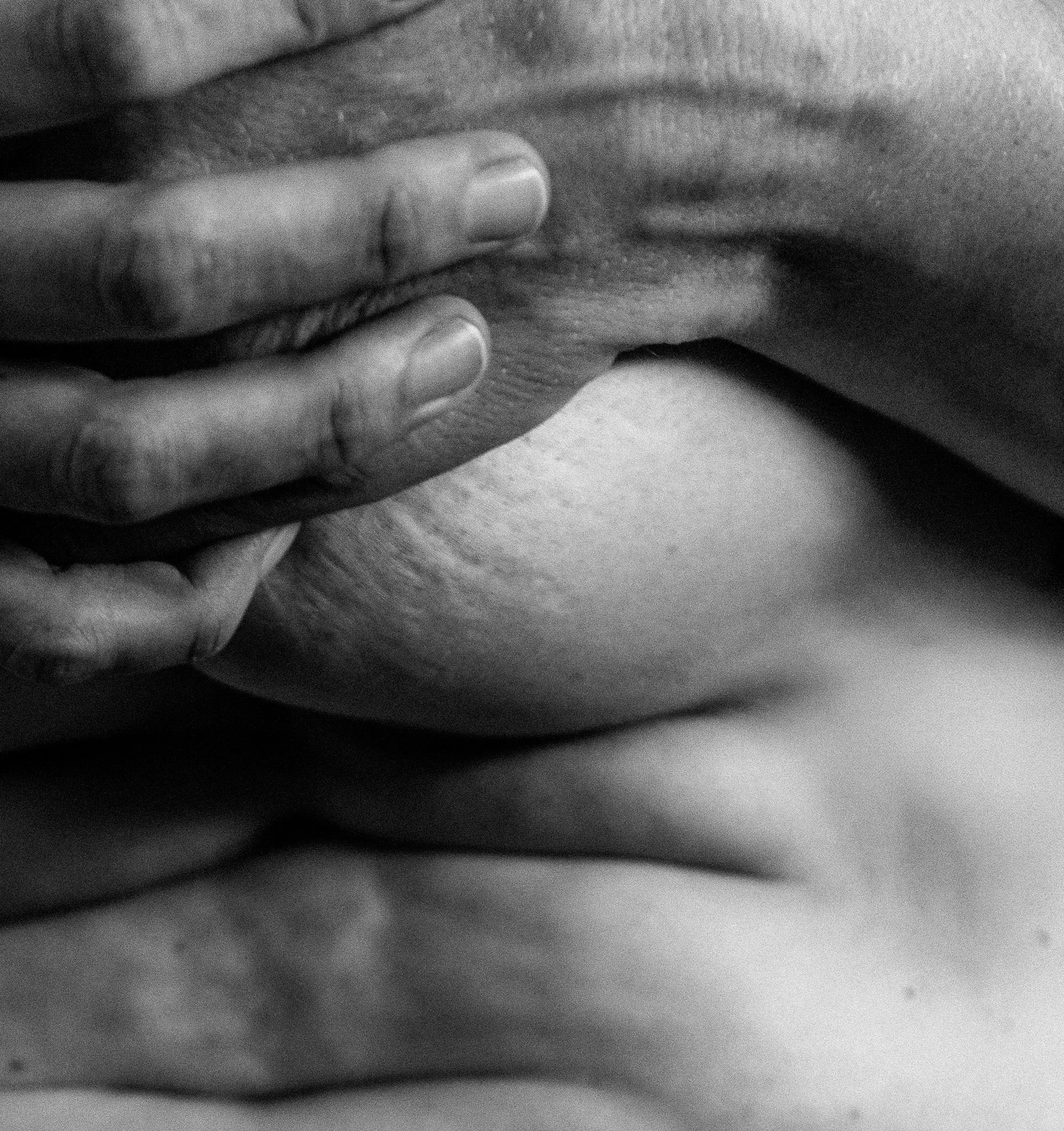 Close-up black and white photo of a person holding their forehead with their fingers, showing a contemplative or stressed expression.