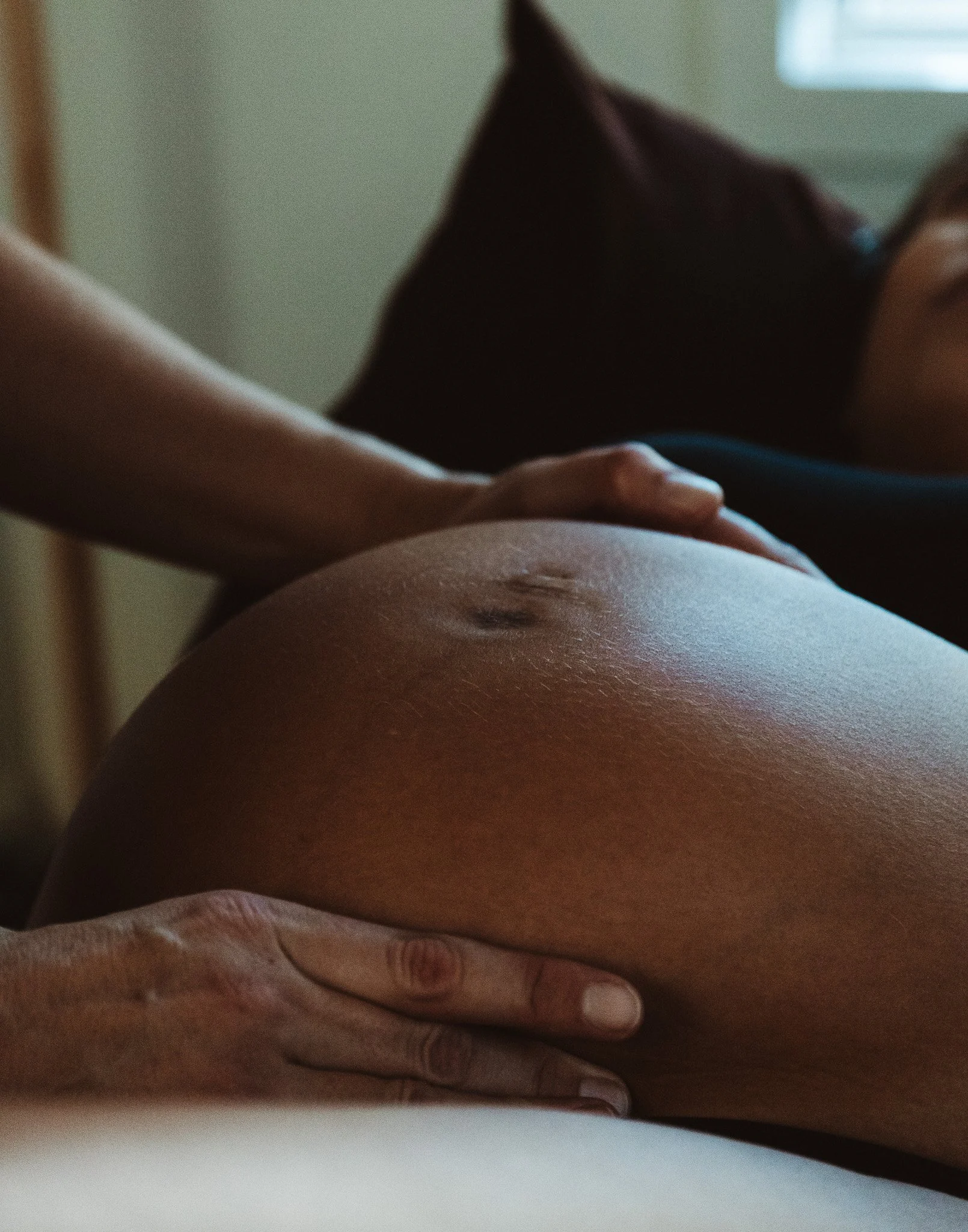 Close-up of a person's hands palpating pregnant belly