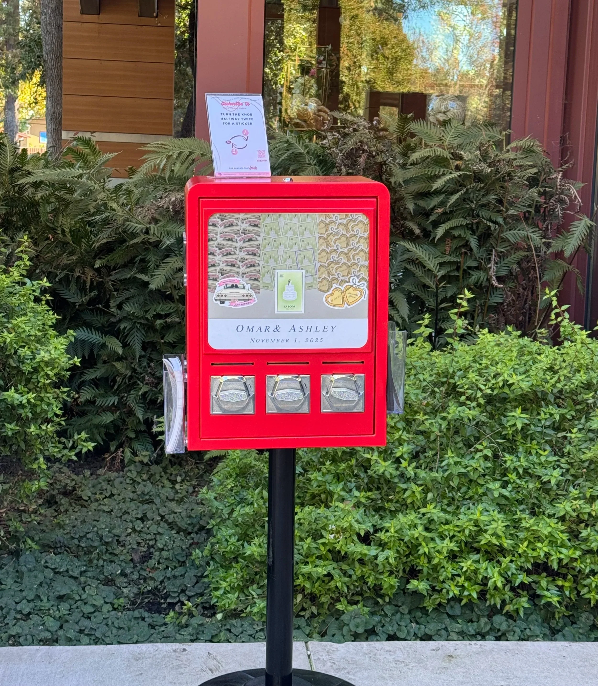 A red memorial donation box outside, featuring wedding details for Omar and Ashley on November 1, 2025, with images of wedding related items and a small flower arrangement.