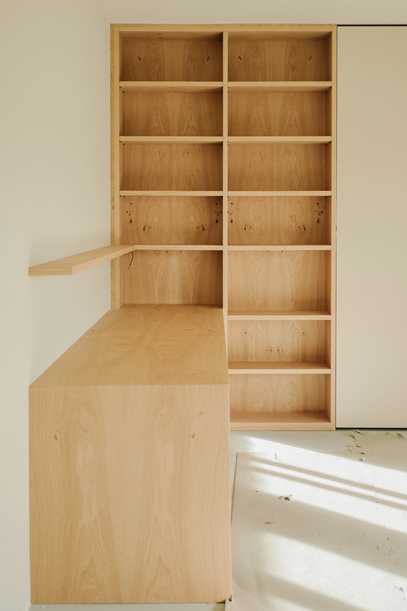 Custom natural timber floating shelving and desk extension installed in a residential room