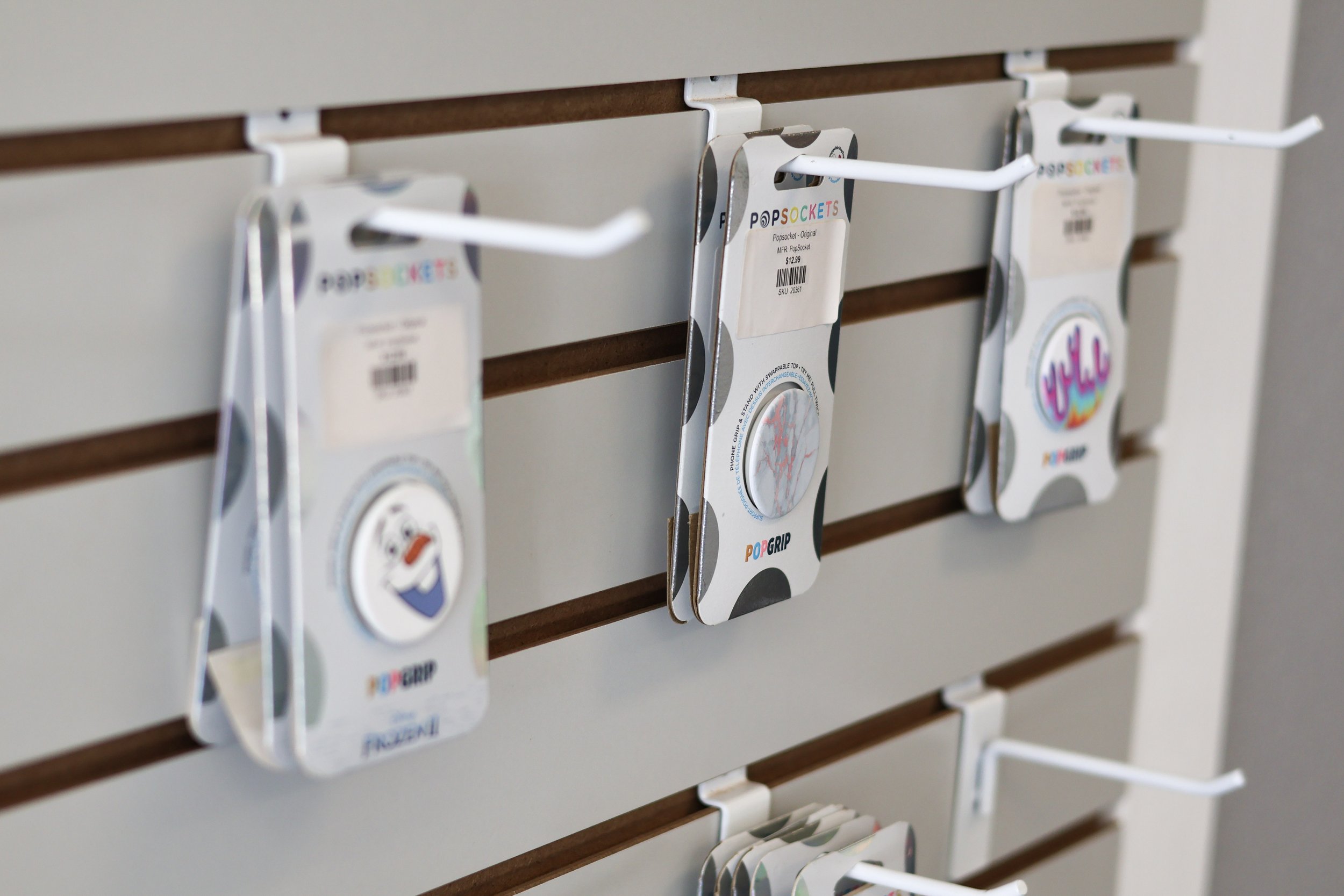 Display of PopSocket grips hanging on a slatwall