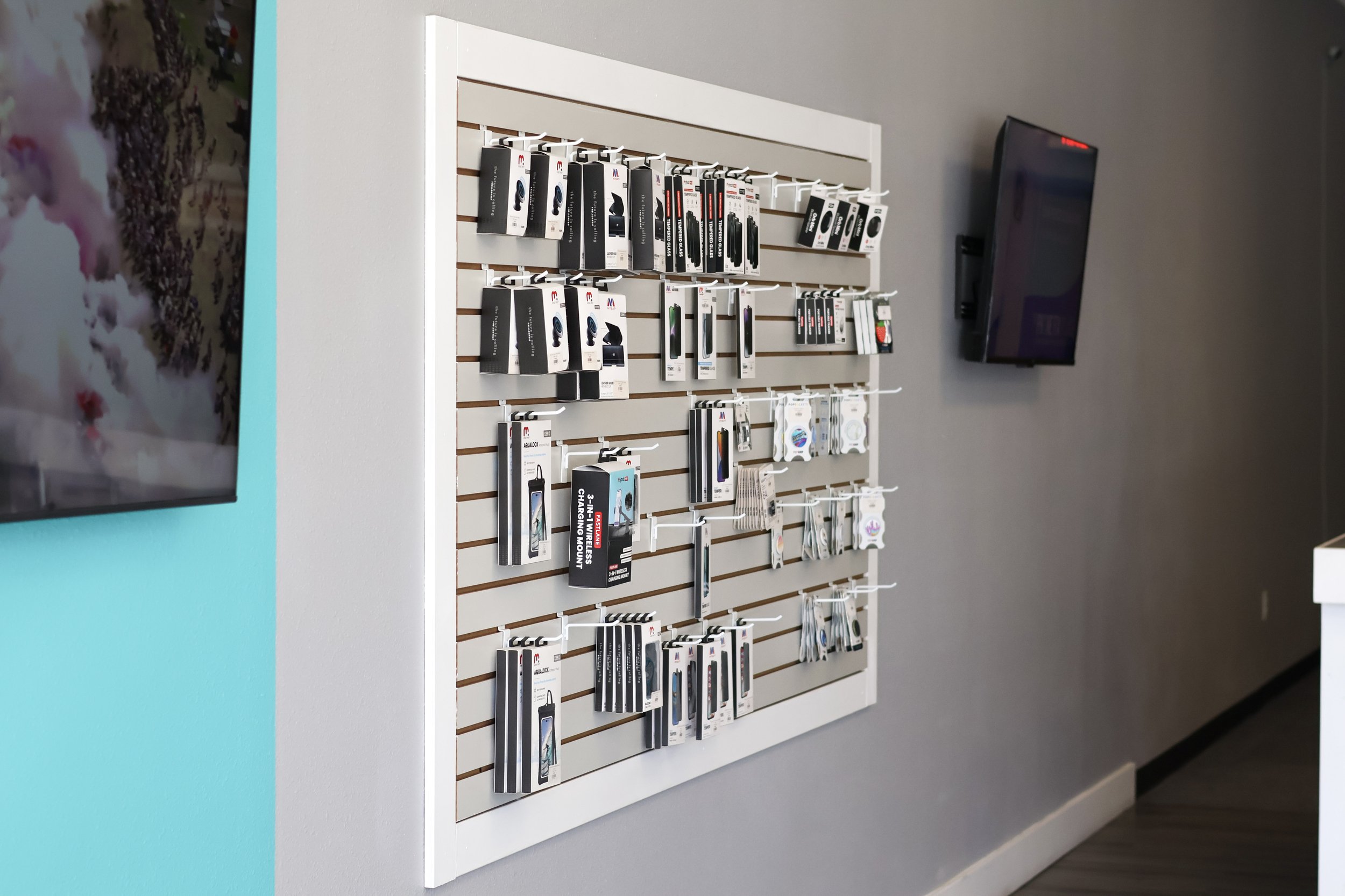 Wall display with various electronic accessories and devices in retail store.