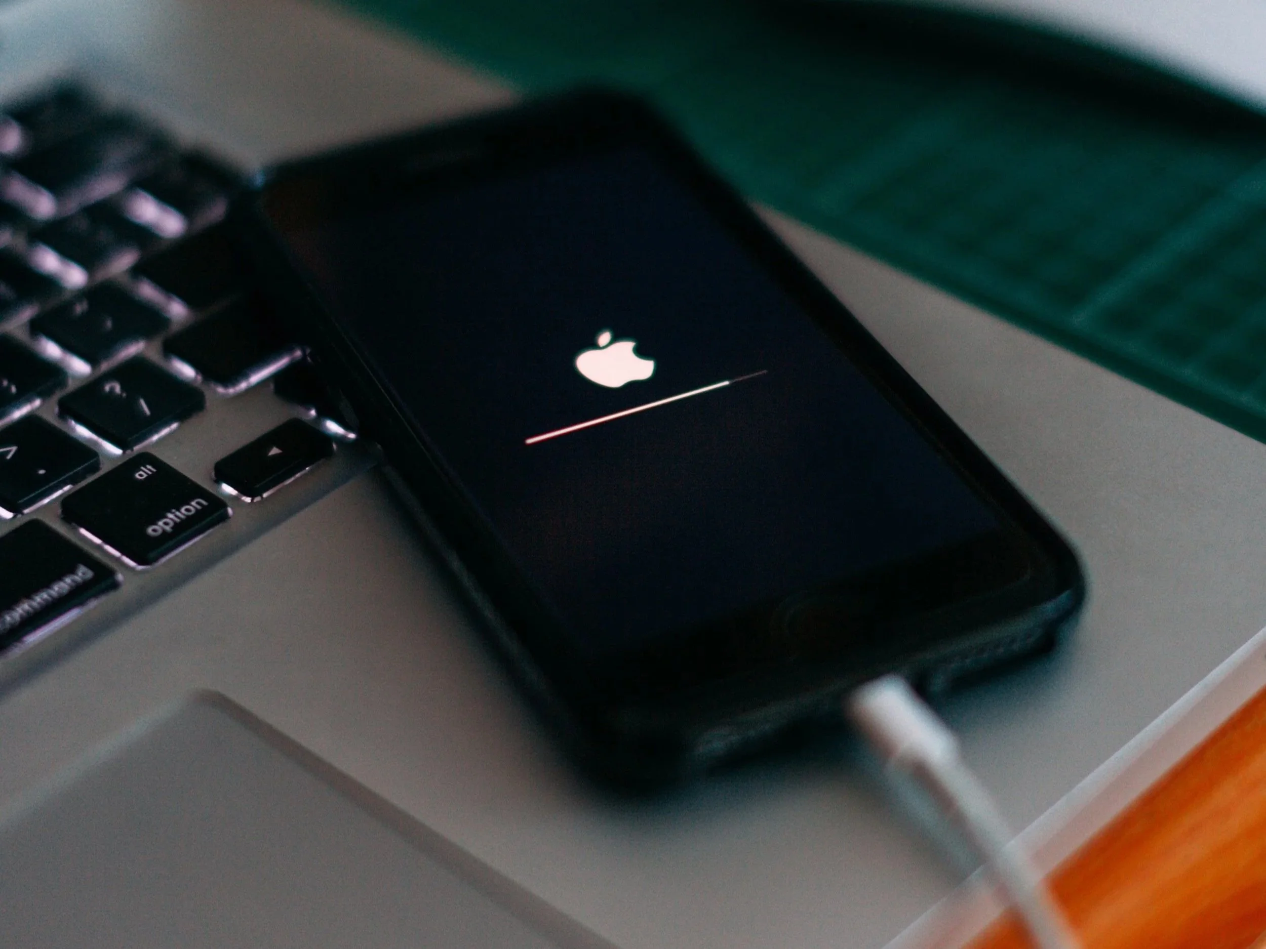iPhone connected to a charger on a desk