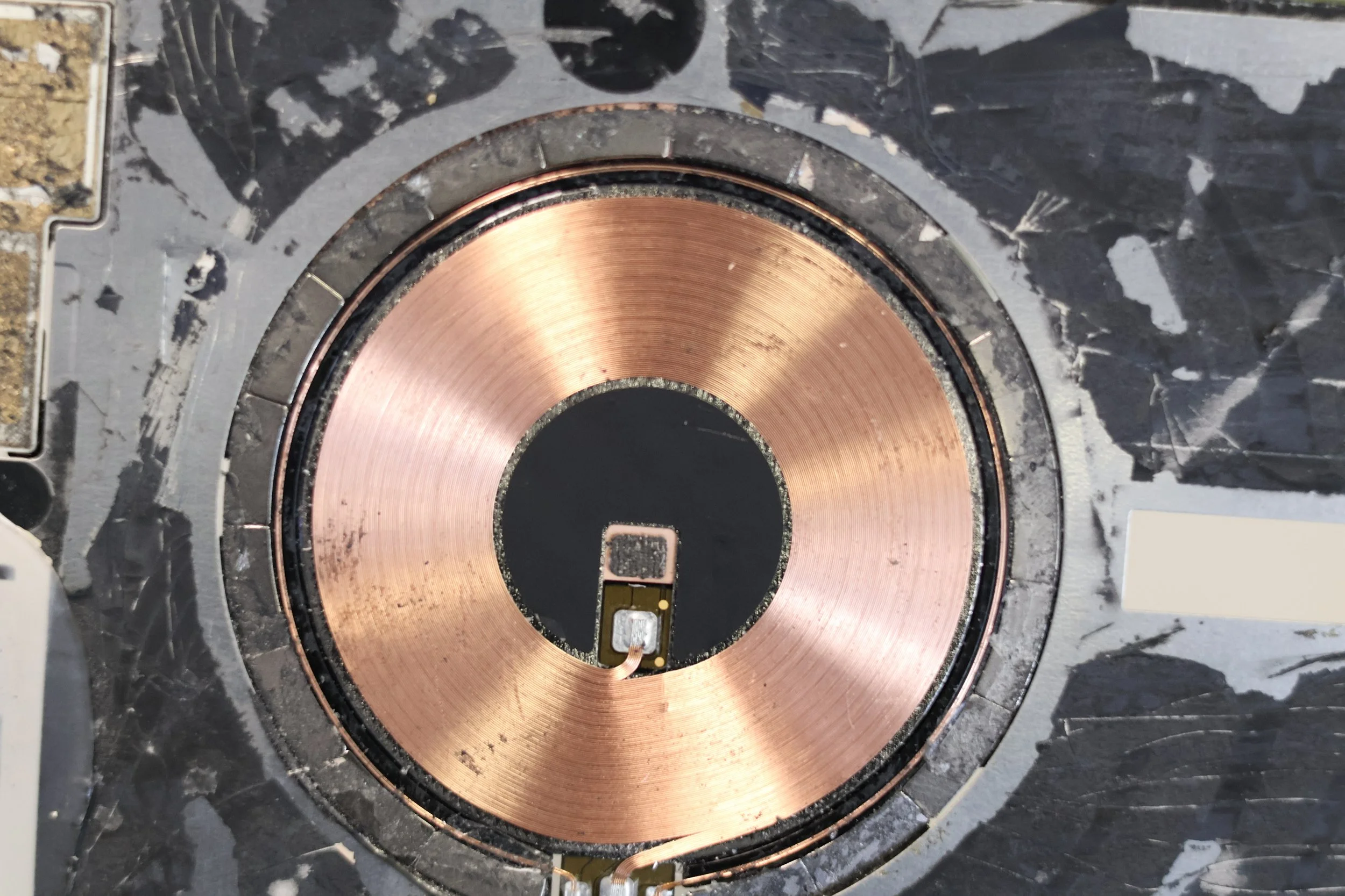 Close-up of a hard drive platter with a read/write head assembly in the center.