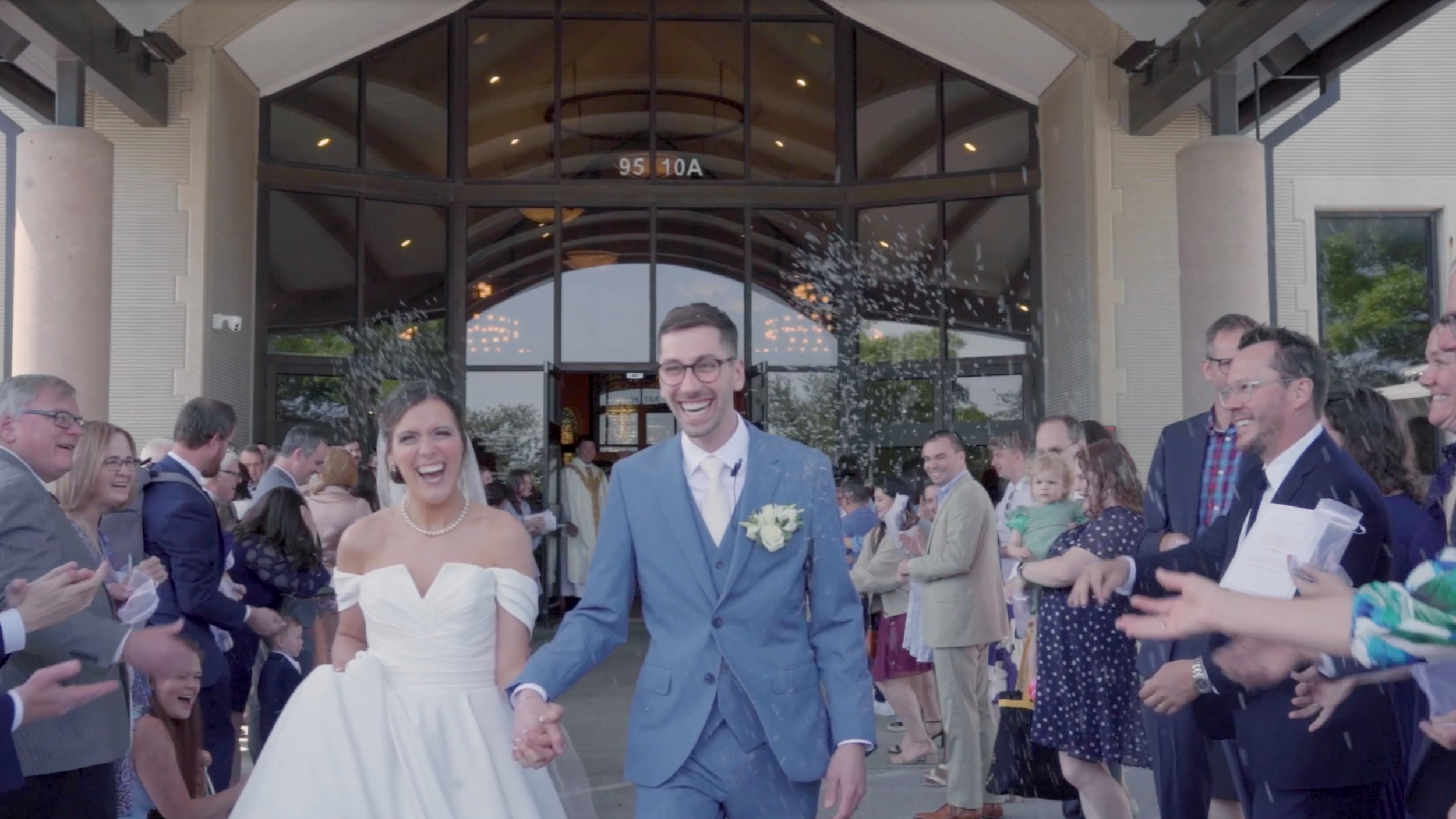 Laurie’s customers, Mariana and Carmen holding hands on a green lawn on their wedding day.