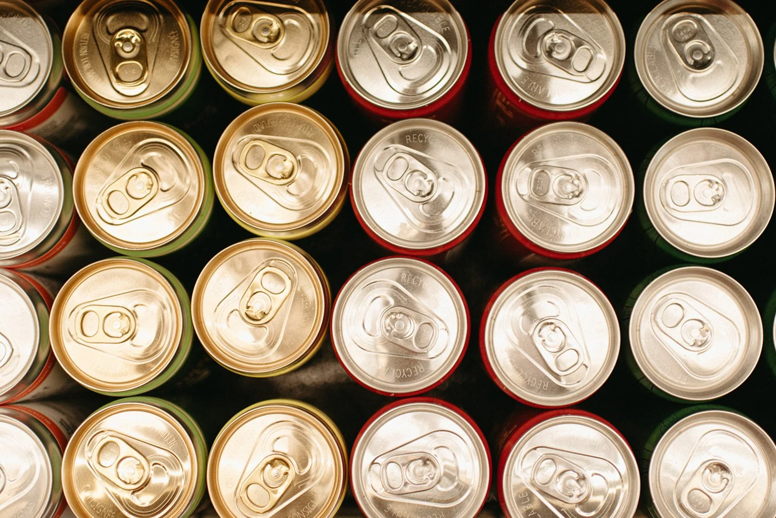 Top view of multiple soda cans arranged in a grid pattern.