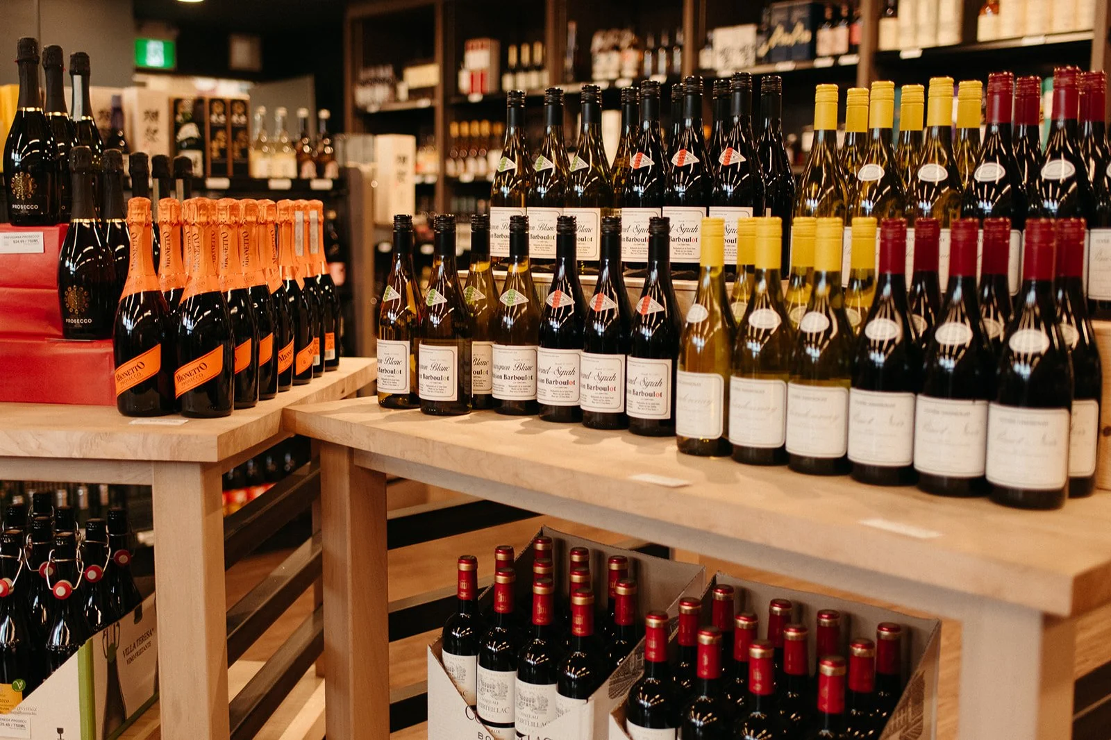 Curated wine selection displayed on wooden shelves at a JAK's Beer Wine Spirits store in Vancouver