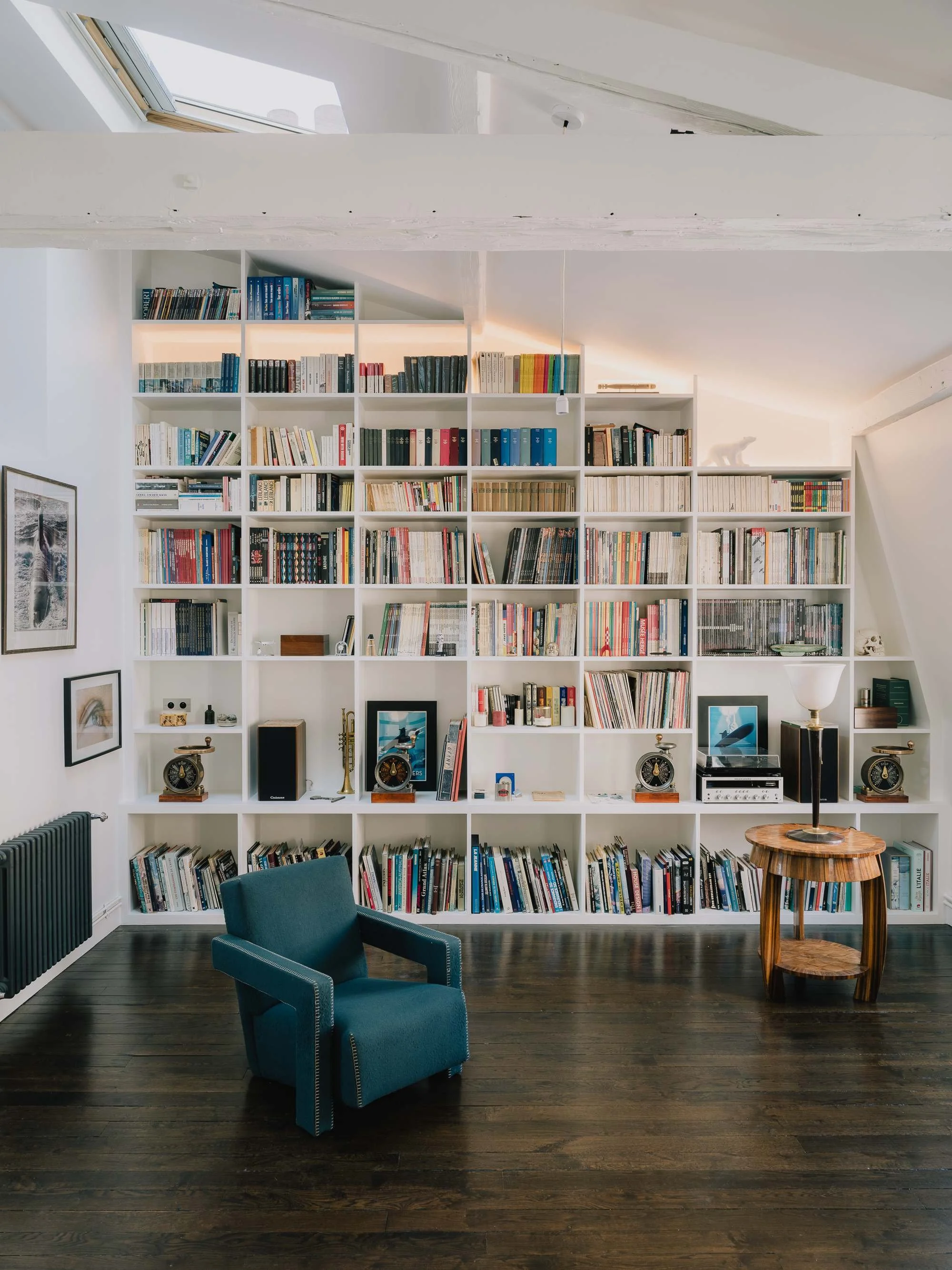 Architecte d'intérieur à Paris. Rénovation complète de et travaux. conception de bibliothèque sur mesure, livres blancs, fauteuil bleu,