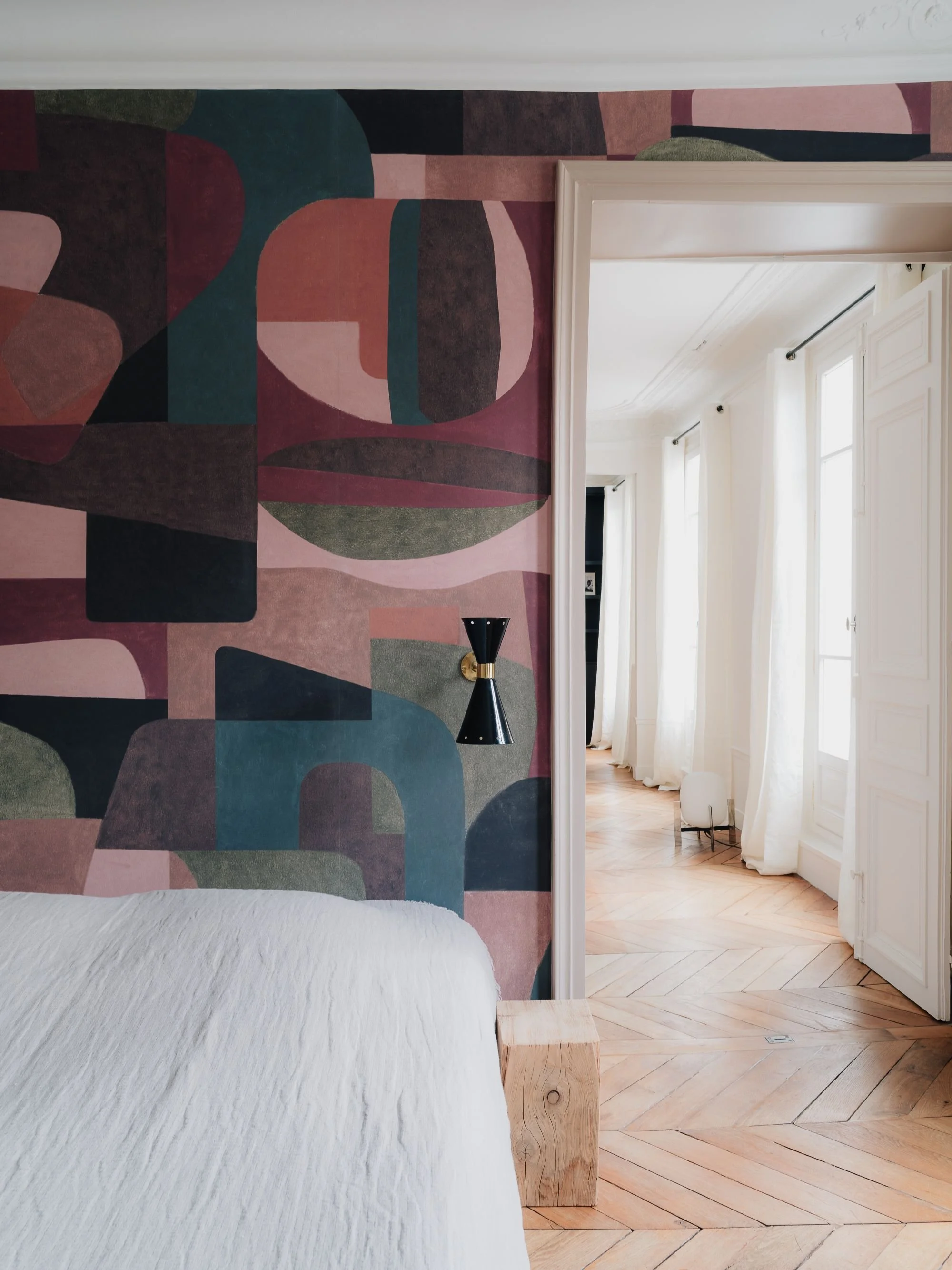 architecte d’intérieur à Paris, aménagement intérieur, Chambre parentale, hausmannien, avec ​t​ête de lit en de papier peint, lit drap lin, sol en parquet, porte entrouverte avec voilage blanc,