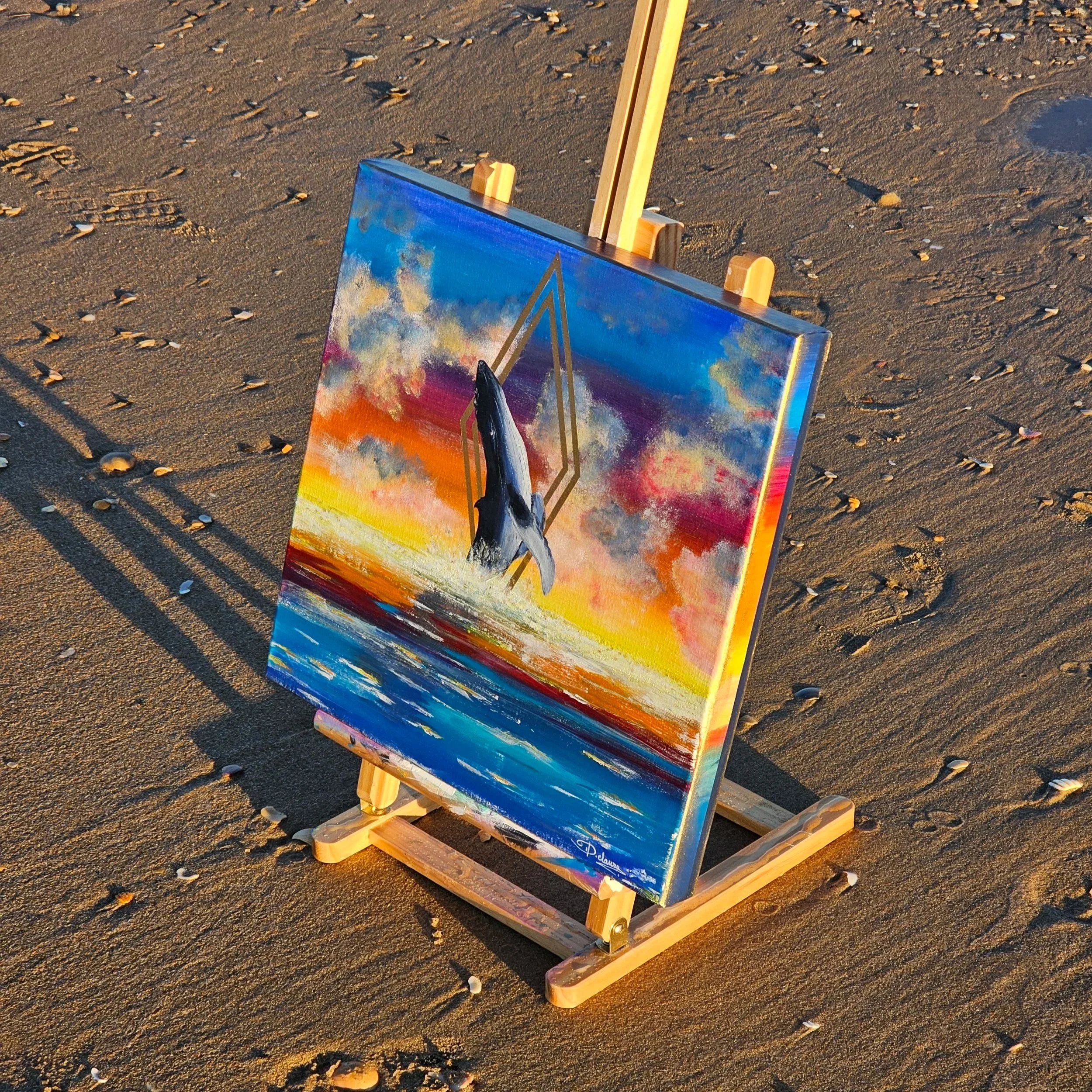 Peinture représentant un océan coloré avec une baleine, "Silence". Elaura Donnadieu, graphiste, illustratrice et artiste peintre. Photo prise sur la plage
